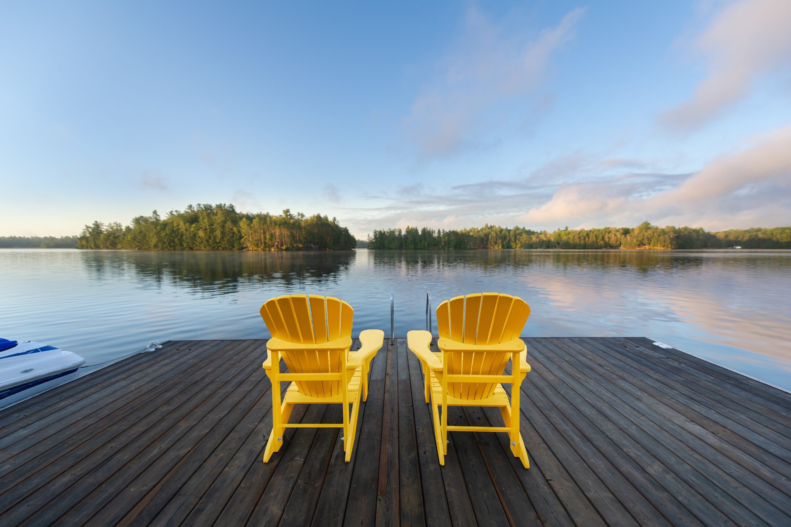 Two,Yellow,Adirondack,Chairs,On,A,Wooden,Dock,Greet,The